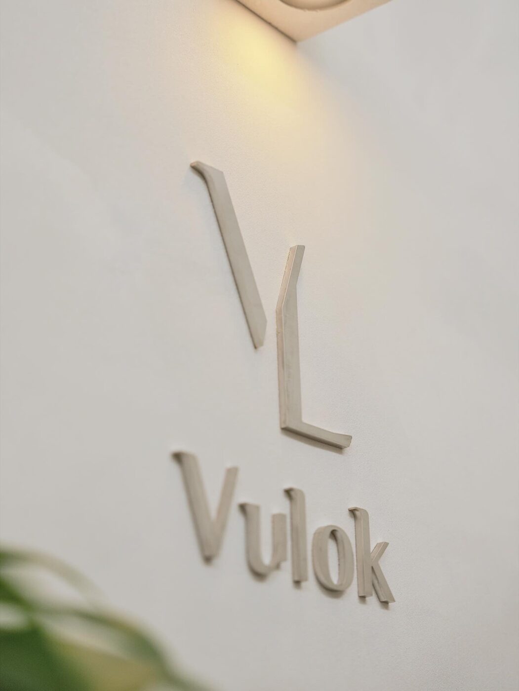 플라스터 벽에 입체로 제작된 Vulok 로고 사인물