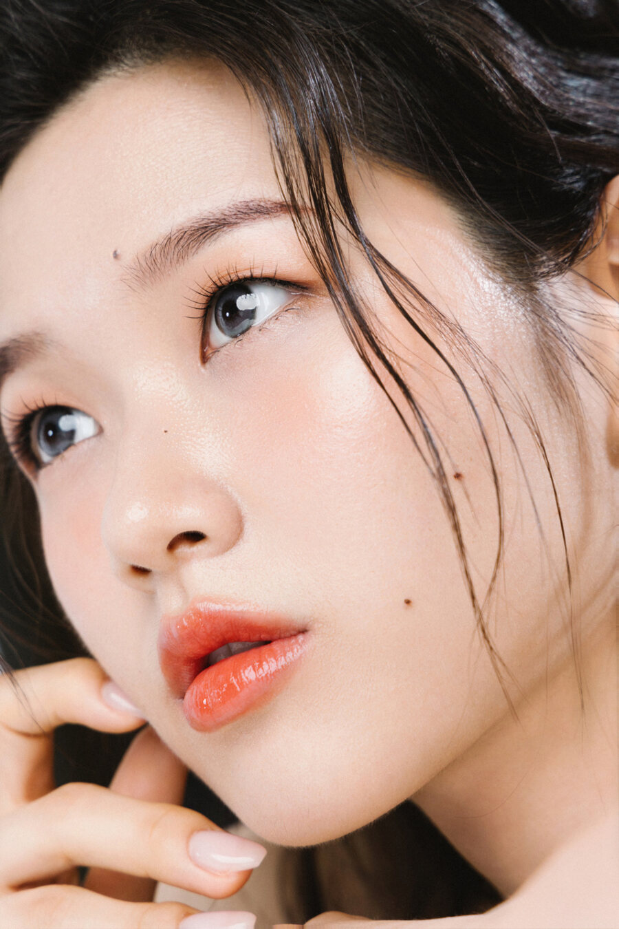 윤기 있는 피부와 코랄 글로스 입술의 뷰티 클로즈업 메이크업
